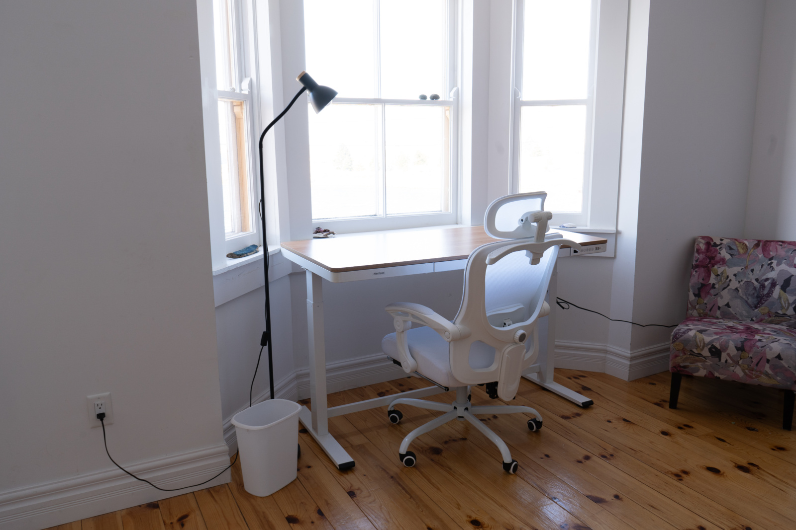 The same model of standing desk placed on the opposite side of the studio, also facing a bay window looking at Port Union.