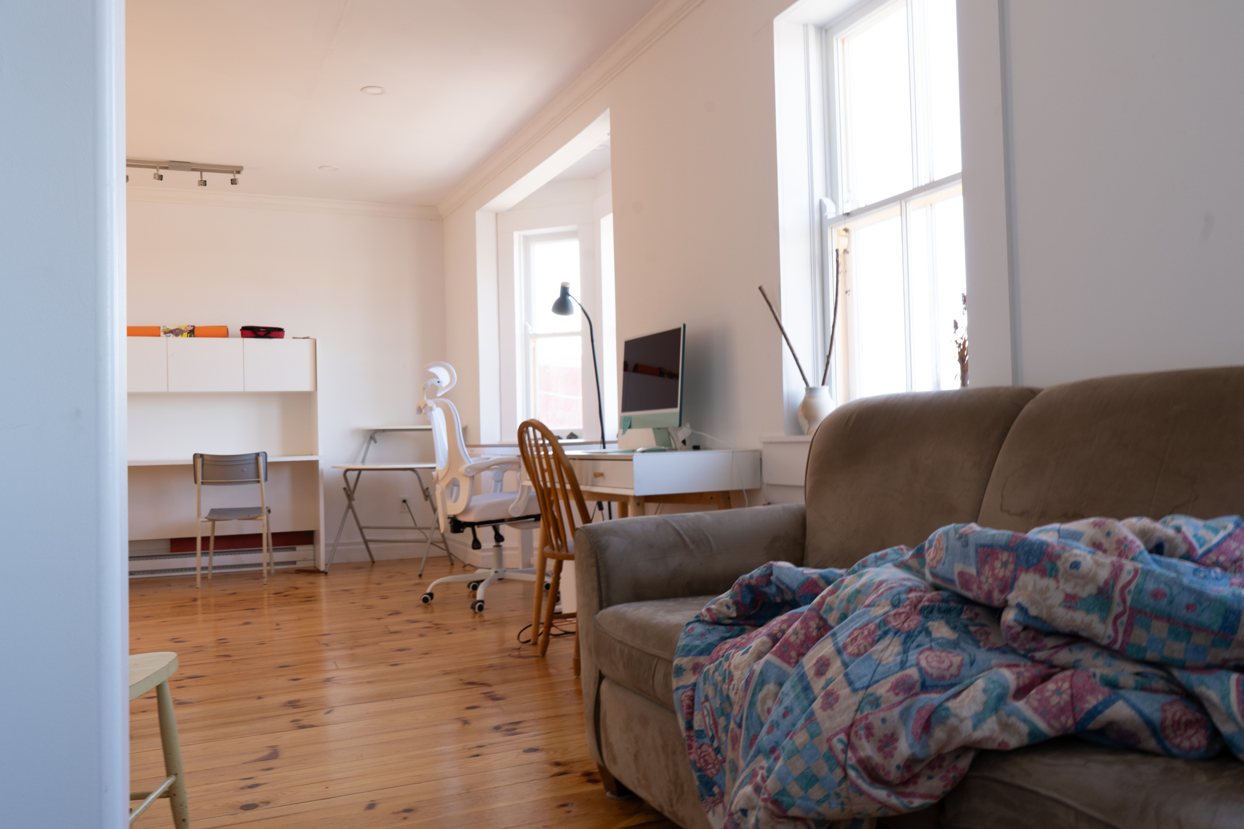 Looking towards an artist workspace with a couch between the two studios in view