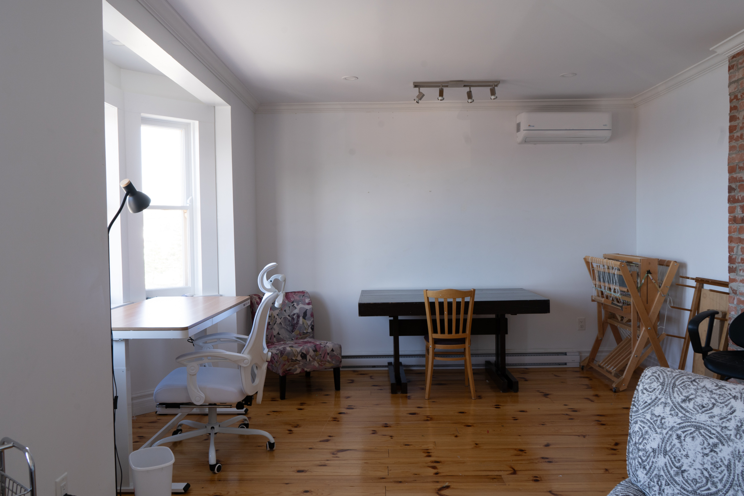 A standing desk and a sitting table for working, extra seating, and a four-shaft loom.